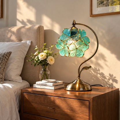 Foglia glass leaf table lamp casting a soft warm glow on a bedroom nightstand
