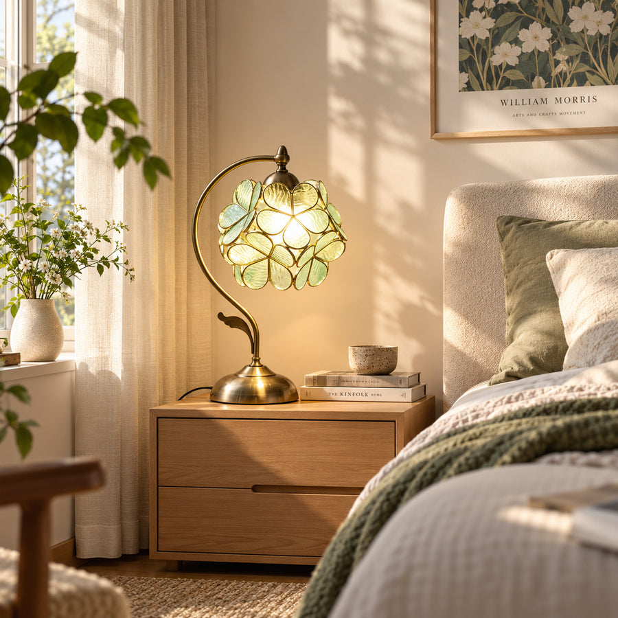 Foglia glass leaf table lamp casting a soft warm glow on a bedroom nightstand