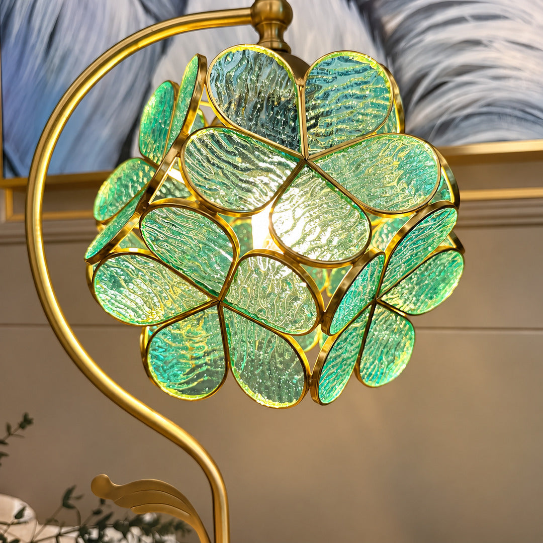 Close-up of the green glass leaves suspended from the brass arm of the Foglia table lamp