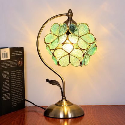 Foglia glass table lamp lighting a cozy corner reading nook with a warm green glow