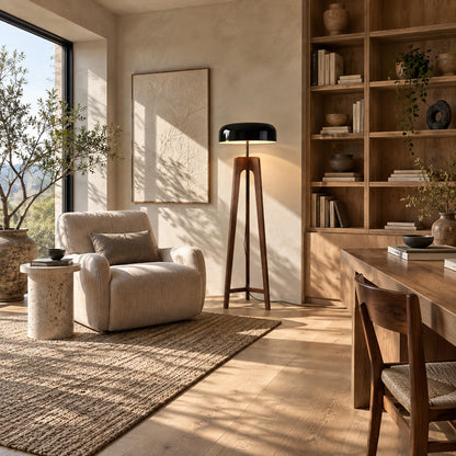 Fungo wood floor lamp casting a soft warm ambient glow over a corner reading chair