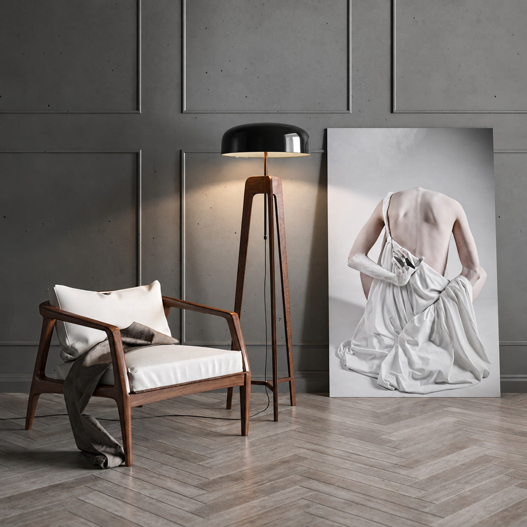 Fungo wood floor lamp casting a soft warm ambient glow over a corner reading chair