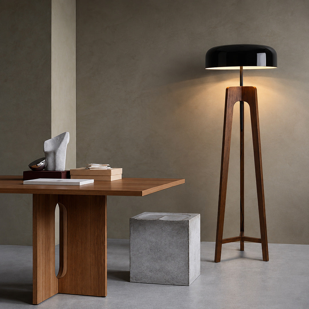 Fungo wood tripod floor lamp filling a living room corner with a soft warm glow