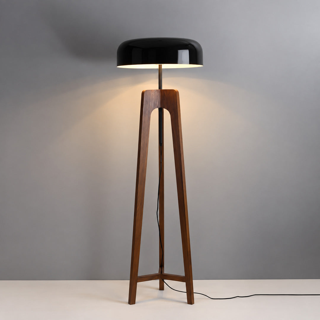 Walnut and black Fungo wood floor lamp standing beside a sofa in a mid-century living room