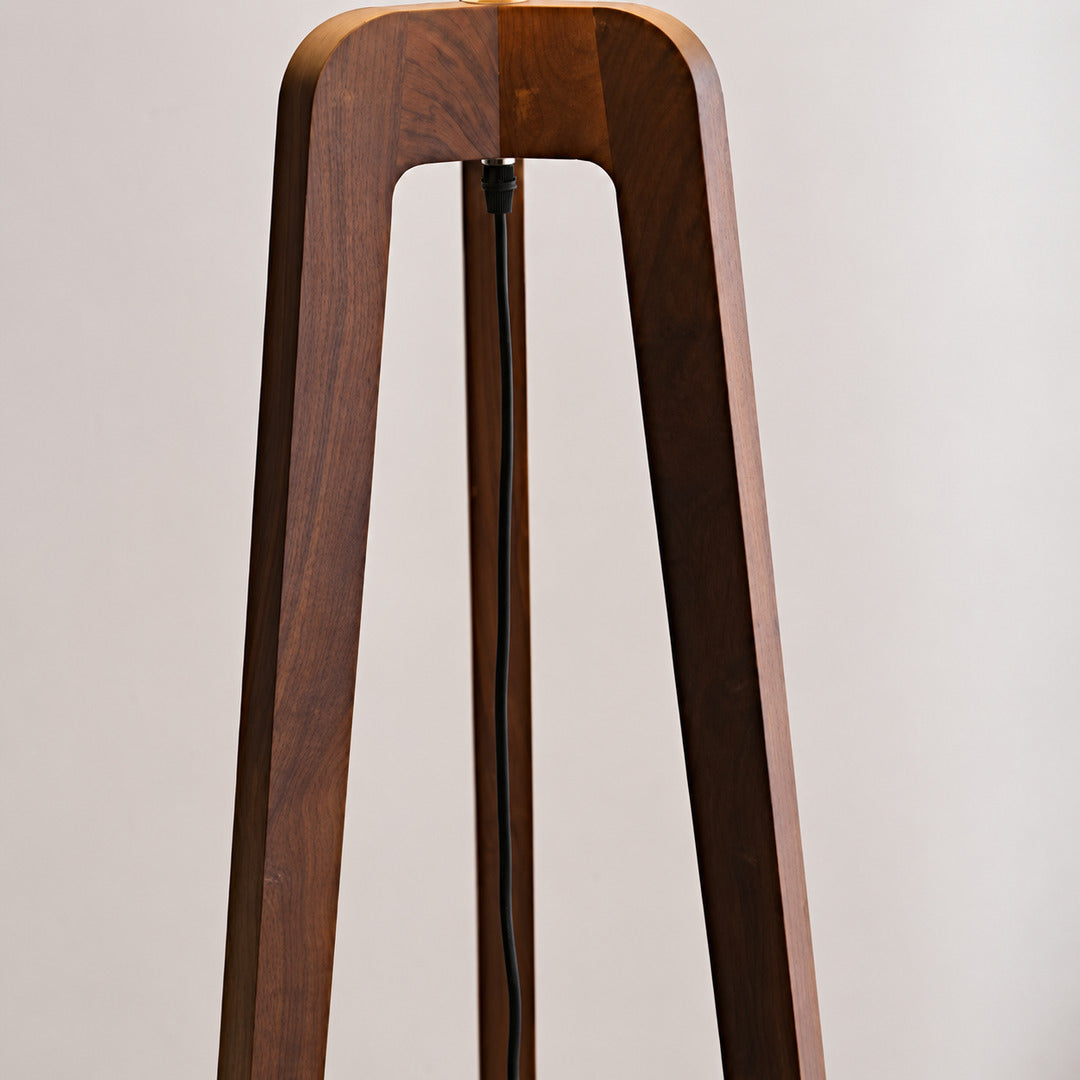 Natural walnut-tinted ash wood grain on the tripod of the Fungo floor lamp, unique to each piece
