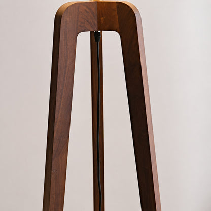 Natural walnut-tinted ash wood grain on the tripod of the Fungo floor lamp, unique to each piece