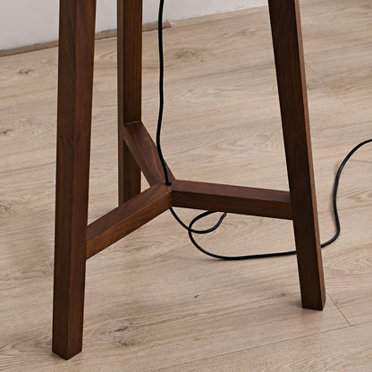 Close-up of the handmade wood tripod base of the Fungo floor lamp showing its rich grain