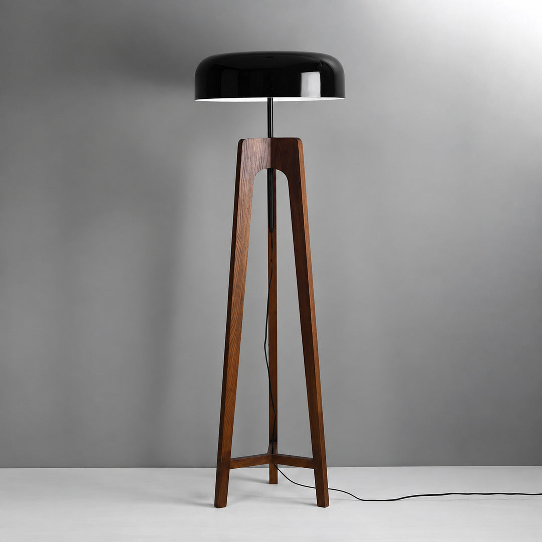 Fungo wood floor lamp with a handmade wood tripod base and a mushroom shade glowing warm in a living room