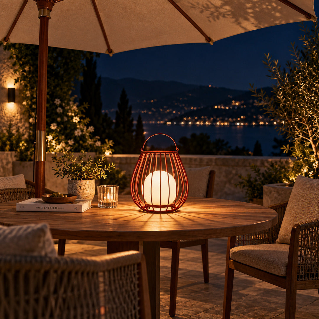 Several Gabbia rechargeable lanterns lining an outdoor dining table for an evening gathering