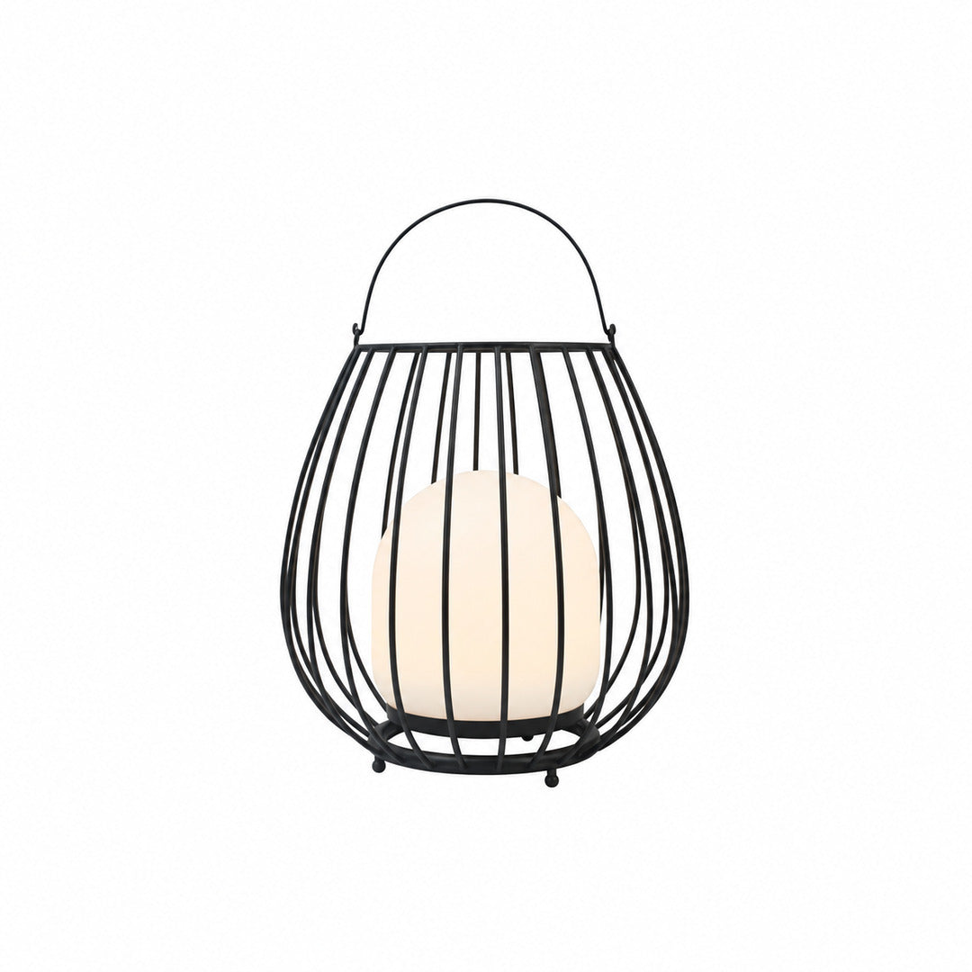 Black Gabbia rechargeable lantern glowing warm on a modern patio table at dusk