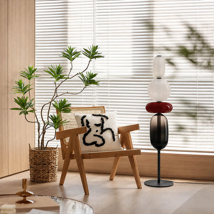 Gemma stacked glass floor lamp Model A green modern reading corner beside armchair hand-blown art glass sculptural warm glow American home lifestyle interior