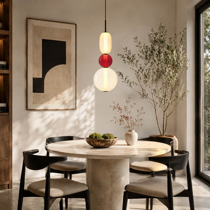 Gemma stacked glass pendant light red clear over round dining table hand-blown art glass warm sculptural glow American home lifestyle interior