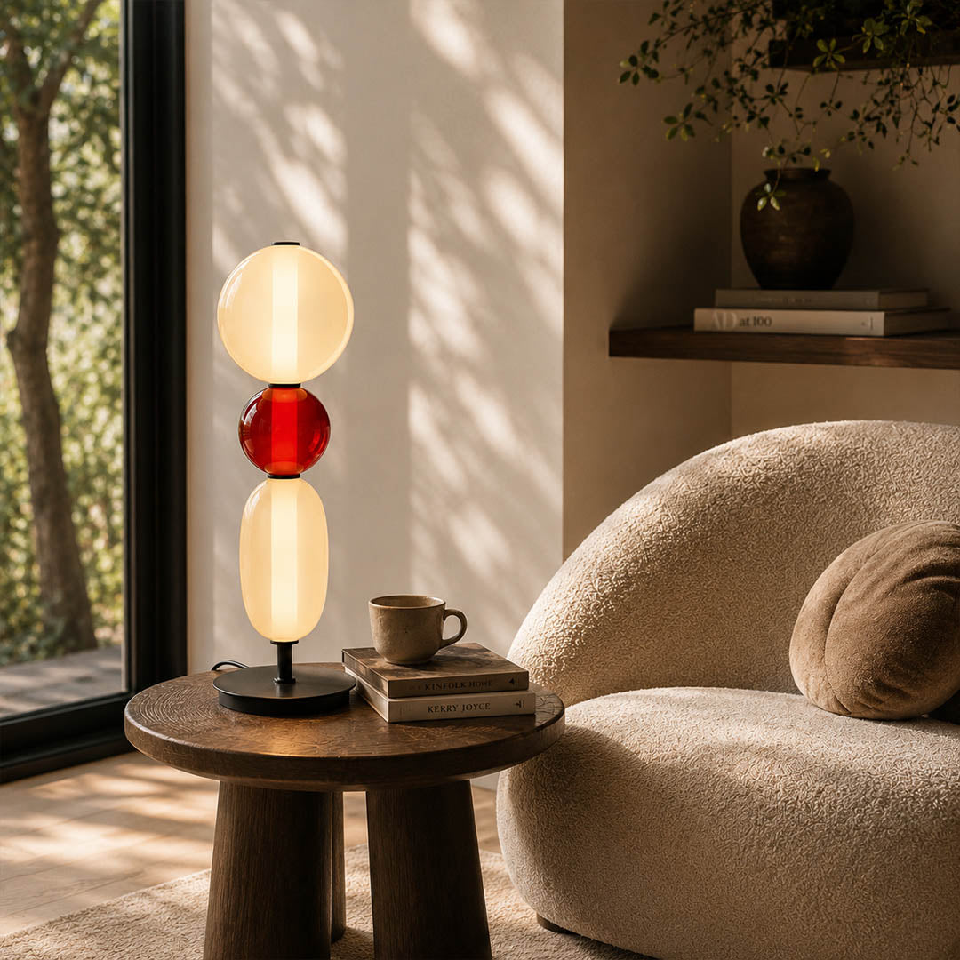 Gemma stacked glass table lamp Model D colorful reading nook beside green armchair hand-blown art glass sculptural warm glow American home lifestyle interior