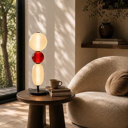 Gemma stacked glass table lamp Model D colorful reading nook beside green armchair hand-blown art glass sculptural warm glow American home lifestyle interior