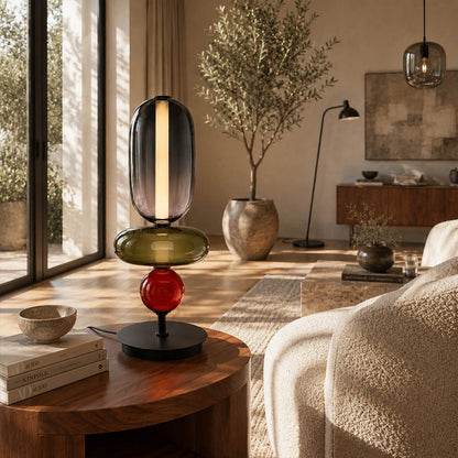 Gemma stacked glass table lamp Model D colorful reading nook beside green armchair hand-blown art glass sculptural warm glow American home lifestyle interior
