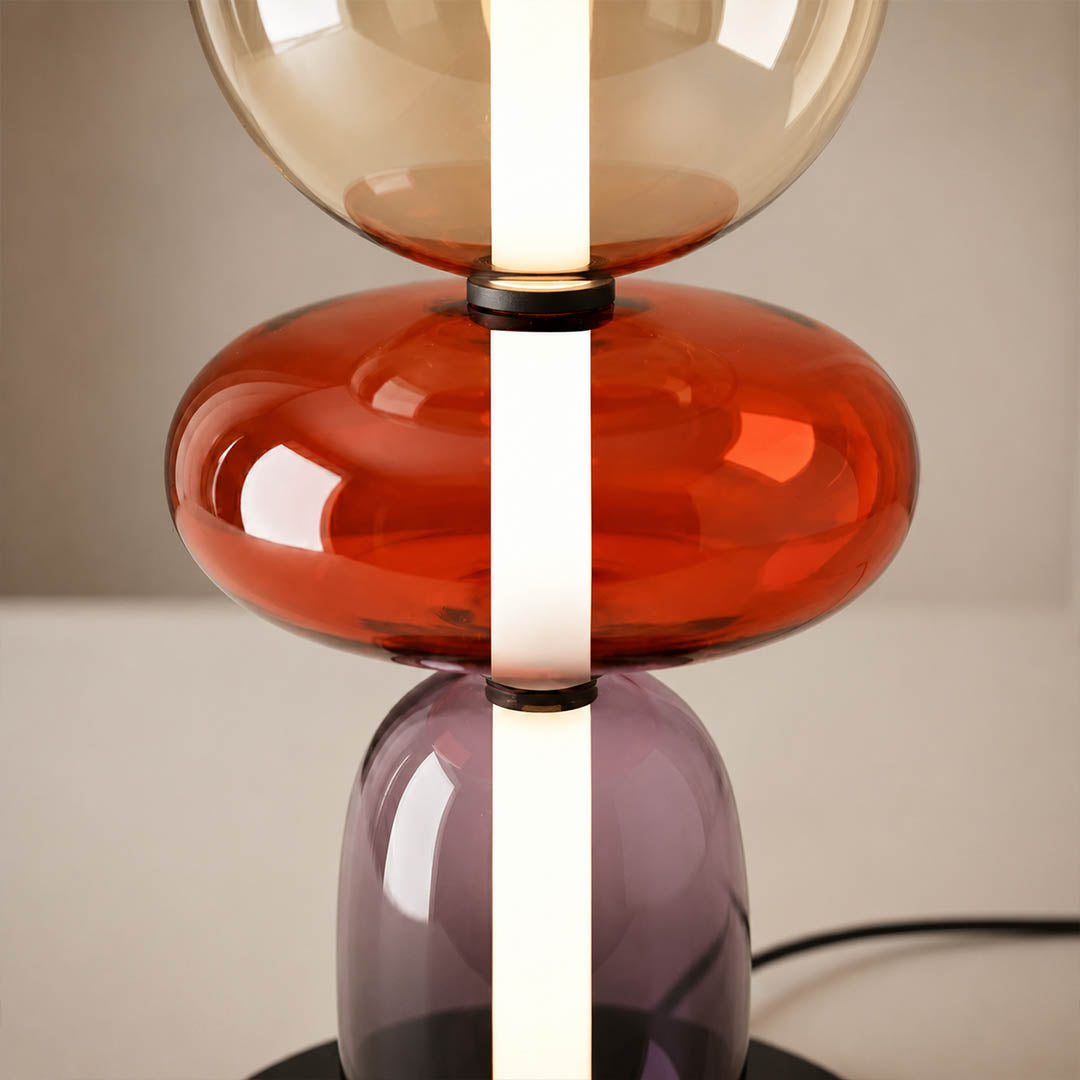Gemma stacked glass table lamp illuminated glowing hand-blown glass forms warm light evening artistic sculptural mood detail close up
