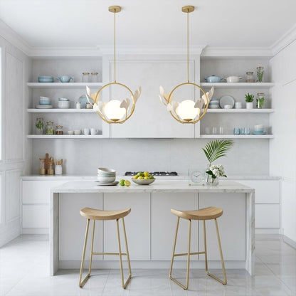 Ginkgo botanical pendant hanging above oval dining table Japandi interior warm glow porcelain leaves brass halo