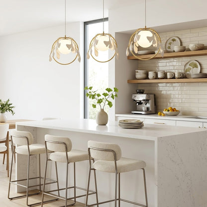 Ginkgo botanical pendant hanging above oval dining table Japandi interior warm glow porcelain leaves brass halo