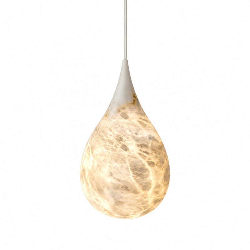 Goccia alabaster pendant light with a raindrop-shaped natural stone shade glowing warm over a kitchen island
