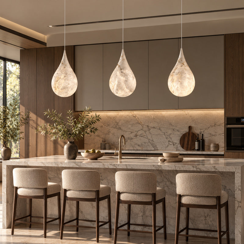 Row of Goccia alabaster raindrop pendants suspended over a modern kitchen island