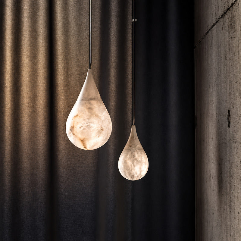 Close-up of the raindrop-shaped natural alabaster shade on the Goccia pendant lit softly from within