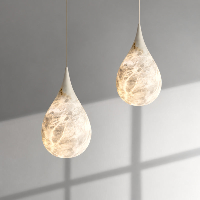 Close-up of the raindrop-shaped natural alabaster shade on the Goccia pendant lit softly from within
