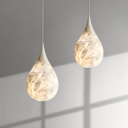 Close-up of the raindrop-shaped natural alabaster shade on the Goccia pendant lit softly from within