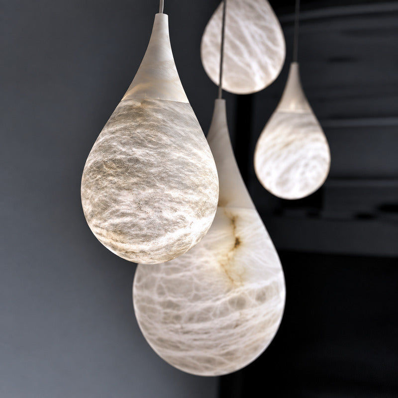 Close-up of the raindrop-shaped natural alabaster shade on the Goccia pendant lit softly from within