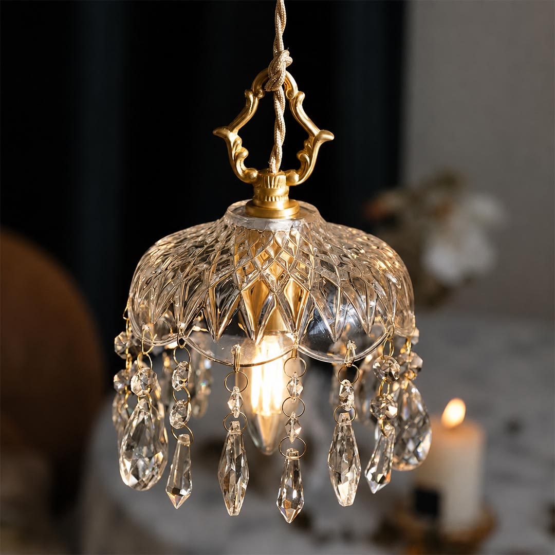 French country vintage brass crystal pendant light hanging above a cozy reading nook with a boucle chair, warm aesthetic home decor.
