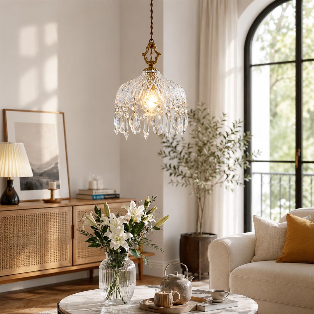 Close-up detail of Goldie vintage brass pendant light featuring an ornate brass hanger, textured cut glass bowl shade, and sparkling hanging crystal droplets with a glowing warm bulb.