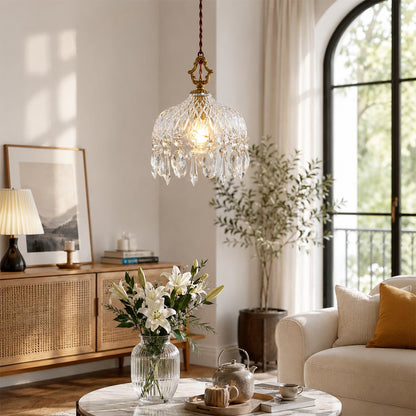 Close-up detail of Goldie vintage brass pendant light featuring an ornate brass hanger, textured cut glass bowl shade, and sparkling hanging crystal droplets with a glowing warm bulb.