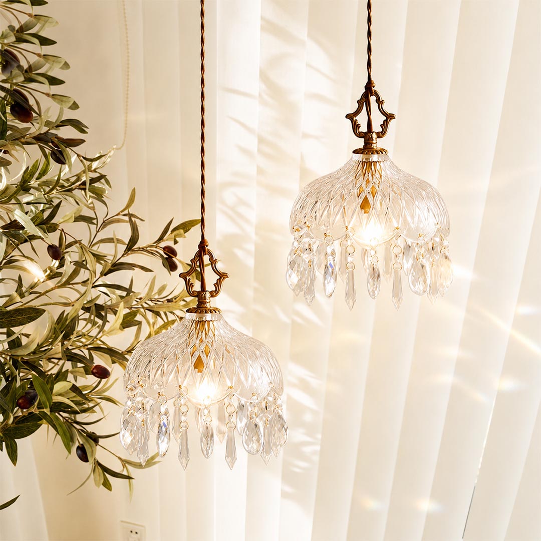 Close-up detail of Goldie vintage brass pendant light featuring an ornate brass hanger, textured cut glass bowl shade, and sparkling hanging crystal droplets with a glowing warm bulb.