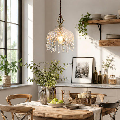 Detailed shot of Goldie brass crystal pendant light, a French vintage style hanging ceiling lamp with clear glass shade and elegant crystal prisms for cozy home decor.