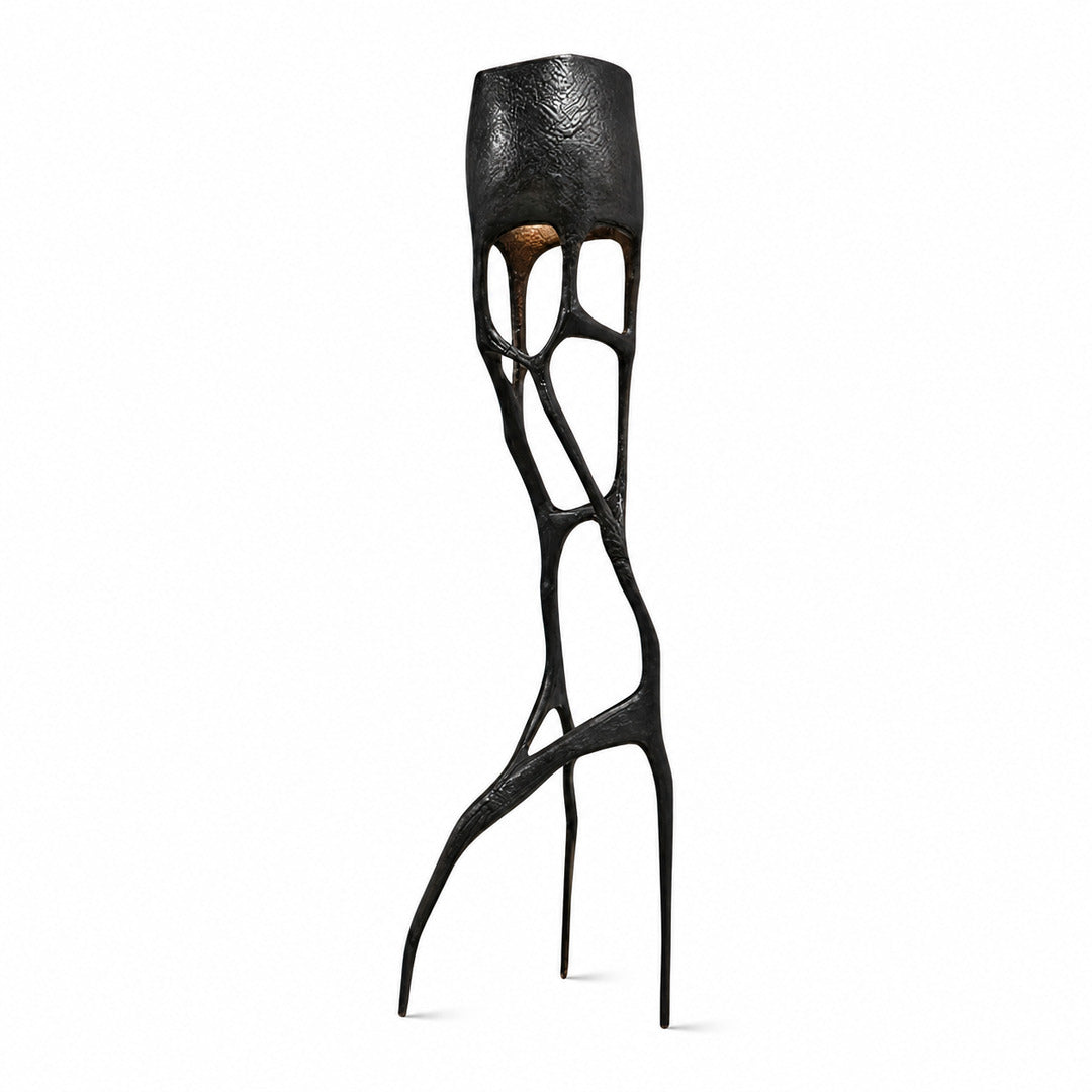 Gotica sculpture floor lamp with an intricate gothic web-like base glowing warm in a modern living room