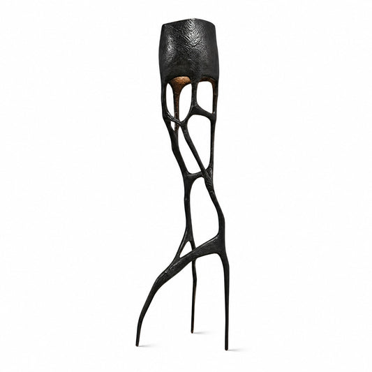 Gotica sculpture floor lamp with an intricate gothic web-like base glowing warm in a modern living room