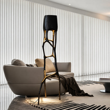 Gotica sculpture floor lamp standing beside a sofa as a dramatic centerpiece in a modern living room
