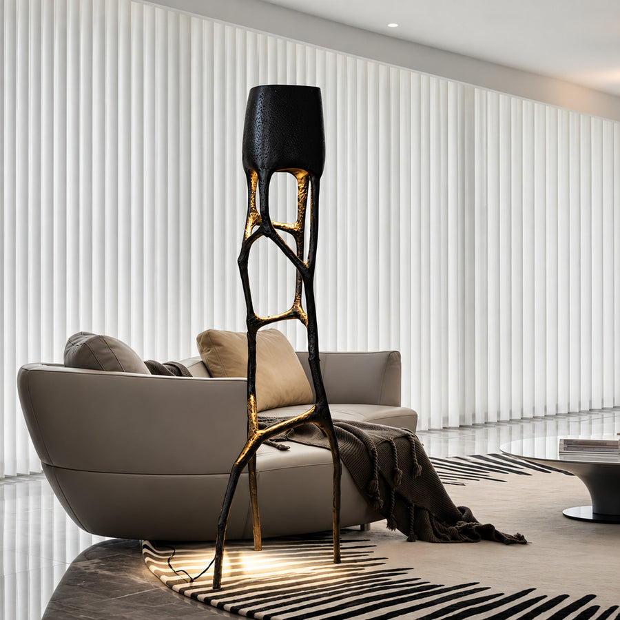 Gotica sculpture floor lamp standing beside a sofa as a dramatic centerpiece in a modern living room