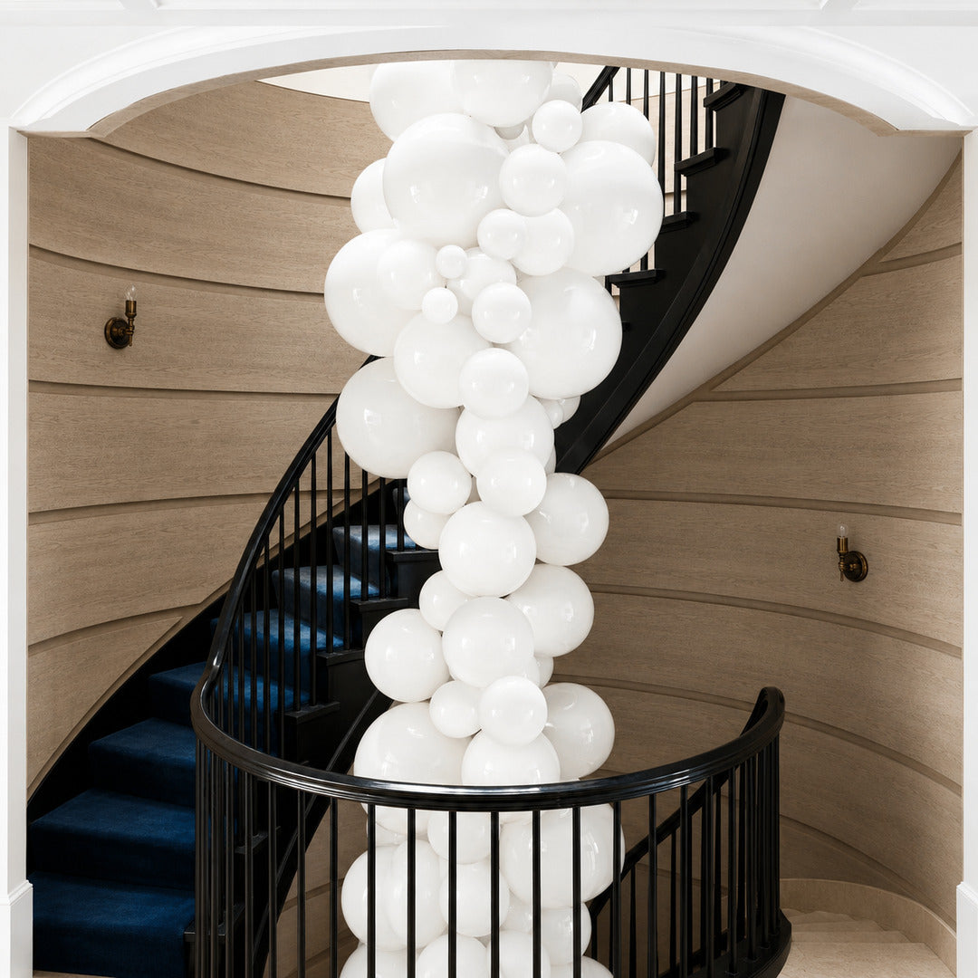 Grappolo glass chandelier flowing down an open staircase stairwell like a cluster of globes
