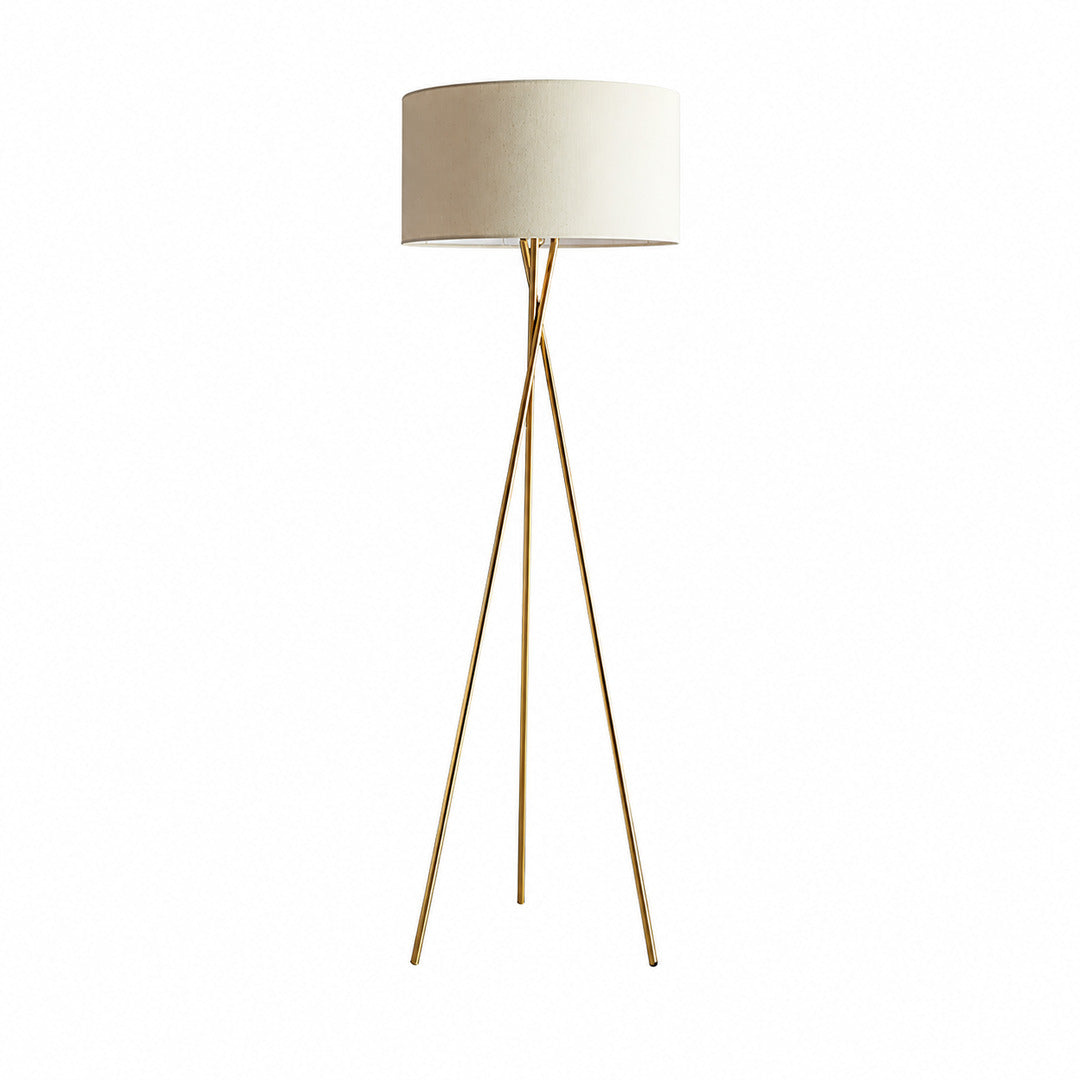 Grazia gold tripod floor lamp with a natural linen fabric shade adding warmth beside a sofa