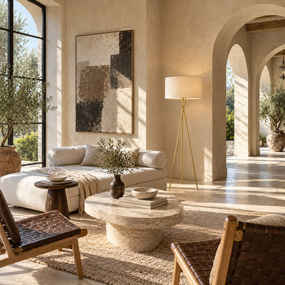 Grazia floor lamp standing beside a sofa as a minimalist gold accent in a living room