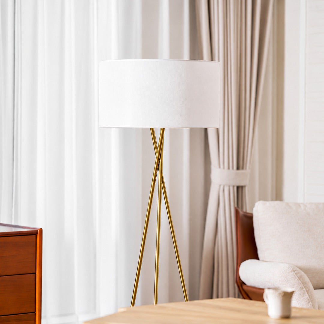 Grazia floor lamp casting a soft warm glow over a corner reading chair