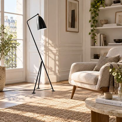 Grillo floor lamp angled over an armchair to provide focused warm reading light