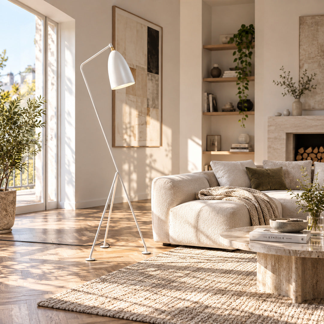 Grillo floor lamp standing beside a sofa directing task light in a modern living room