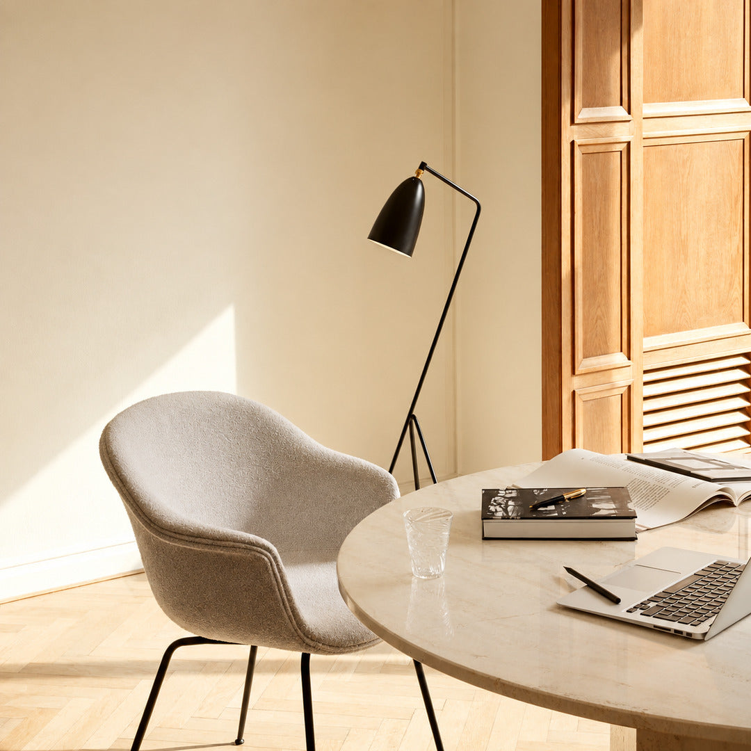 Grillo angled metal floor lamp filling a living room corner with a warm glow