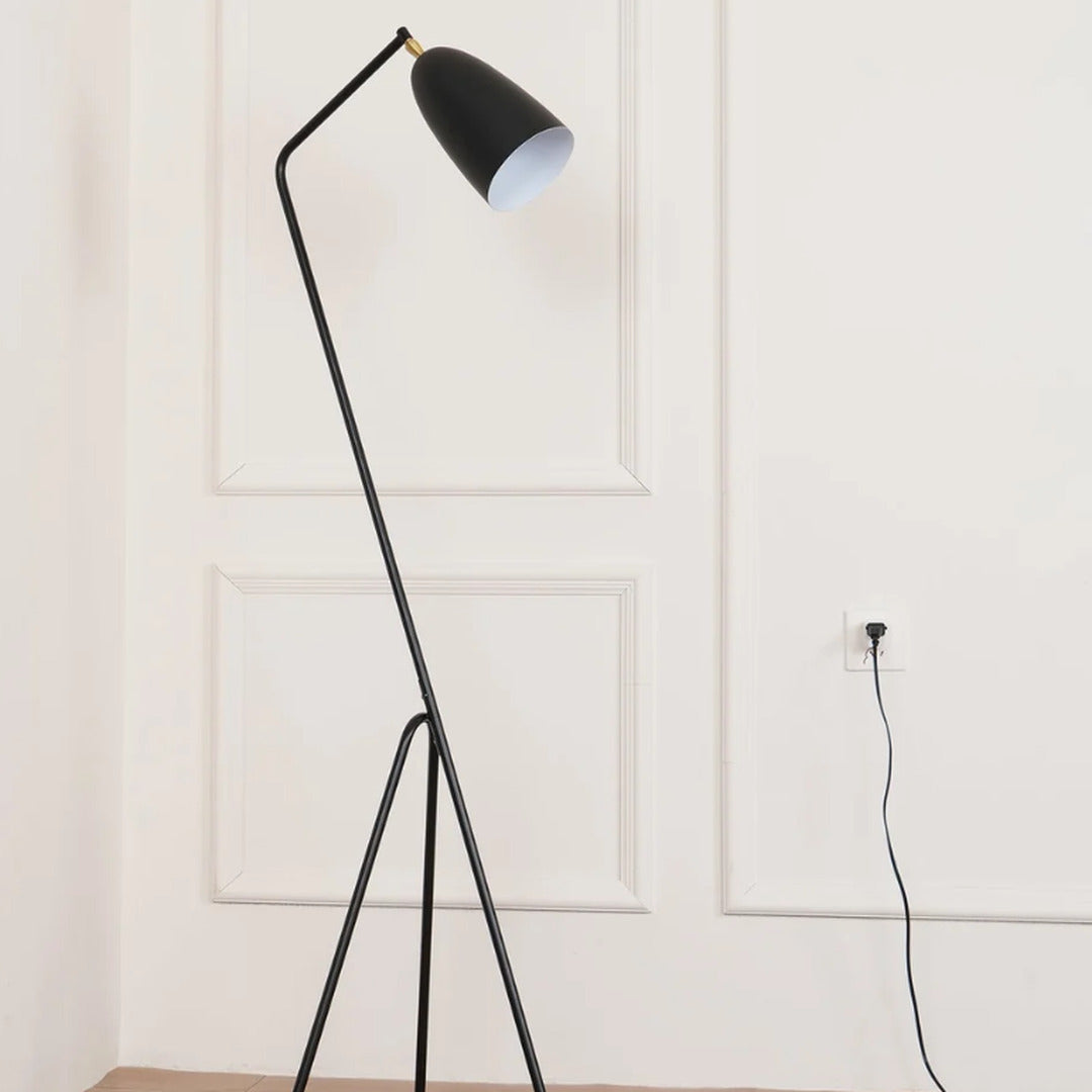 Grillo angled metal floor lamp filling a living room corner with a warm glow