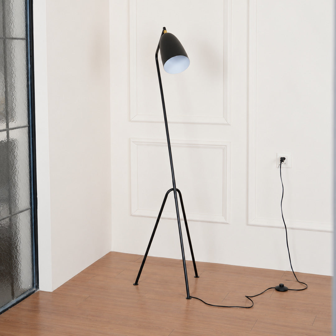 Grillo angled metal floor lamp filling a living room corner with a warm glow