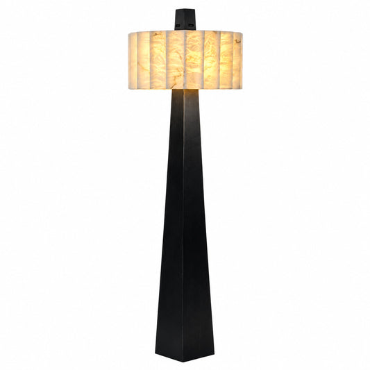 Guglia modern alabaster floor lamp with a tapered black obelisk base and glowing alabaster shade in a living room