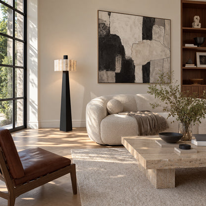 Guglia alabaster floor lamp glowing beside a sofa in a modern living room