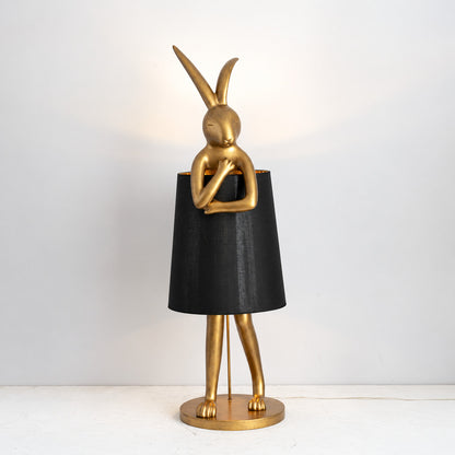 Vintage gold Hare silhouette table lamp with a black shade as a bold accent on a shelf