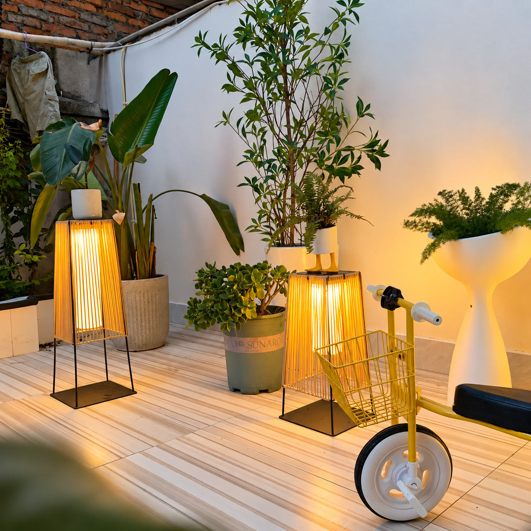 Tall Intreccio outdoor post light standing as a floor lantern on a backyard deck